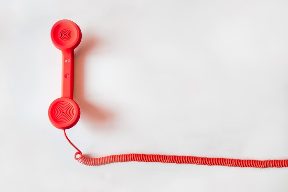 Old Red Phone on a White Background Representing Offline Marketing